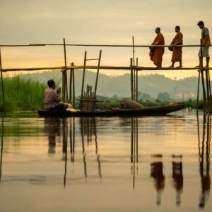 monjes caminando por un puente al atardecer