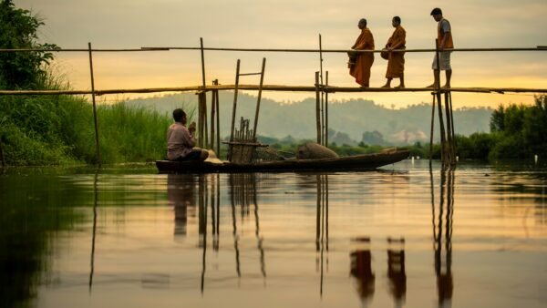 monjes caminando por un puente al atardecer